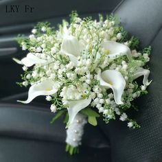 a bridal bouquet sitting in the back seat of a car with white flowers and baby's breath