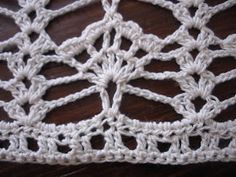 crocheted doily sitting on top of a wooden table