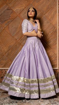 Waltz into your next wedding event with this show-stopping lilac lehenga choli﻿ that comes with a cut-out blouse with zari detailing, a stunning lehenga skirt, matching dupatta and potli bag. The blouse has a unique heart-shaped cut-out and can be customized upon request. It comes with a stunning flared lehenga crafted on cotton silk fabric with a thick gota lace border. Total No of Set-3Blouse Fabric : Cotton SilkWork Done on the entire set- Print, gota & lace detailing with dori and tasselsSle Rajasthani Dress, Cotton Lehenga, Indian Outfits Lehenga, Indian Bride Outfits, Potli Bag, Choli Designs, Indian Dresses Traditional