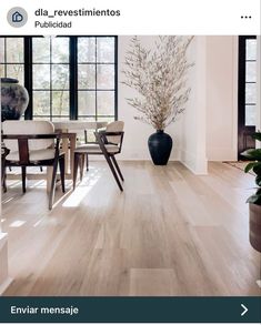 a living room filled with furniture and a plant in a vase on the floor next to a window