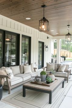 a living room filled with furniture on top of a hard wood floored porch area