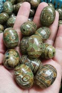 a person is holding some green marble beads