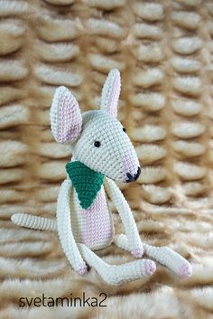 a crocheted white dog with a green bow tie on it's neck