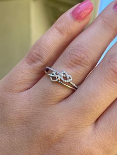 a woman's hand with pink manicures and a ring on her finger