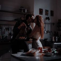 a man and woman kissing in the kitchen