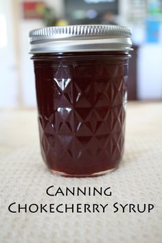 a close up of a jar of food on a table with the words canning chokeberry syrup