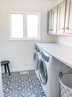 a washer and dryer sitting in a room next to a counter with a stool