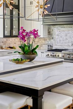 a kitchen with marble counter tops and an island in front of a stove top oven