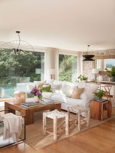 a living room filled with furniture next to a large window covered in lots of windows