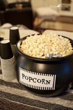 a black bowl filled with popcorn sitting on top of a table