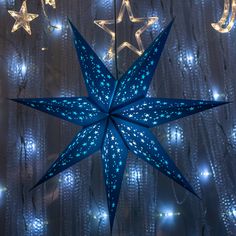 a blue star hanging from the side of a building with lights around it and stars