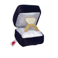 an open black and white box with a gold ring inside