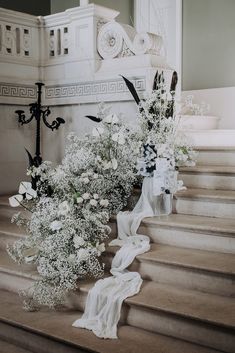 some white flowers are sitting on the steps