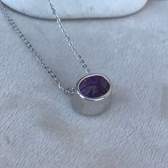 "A top-quality flawless genuine, natural faceted oval-shaped dark purple amethyst set in a simple minimal sterling silver bezel setting which directs the eye to the stone rather than the metal is a very unique pendant necklace. The pendant is suspended on a sterling silver satellite style 18\" long chain. Belesas and 925 hallmarked on the side of pendant. Amethyst is the birthstone of February. Wrapped in a box ready for gift giving.(n-182-6) Oval Purple Amethyst 12mm L x 10mmW x 8.5mm D 18\" le Purple Amethyst Oval Pendant Jewelry, Purple Gemstone Oval Pendant Necklace, Purple Gemstone Necklace With Oval Pendant, Purple Oval Gemstone Necklace, Purple Amethyst Oval Pendant Necklace, Purple Oval Stone Jewelry, Purple Oval Jewelry With Stones, Oval Lavender Gemstone Necklace, Purple Oval Stones Jewelry