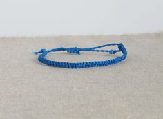 This listing is for one tiny cord bracelet, handmade by macramé, in blue. Perfect jewel for him or for her, comfortable, resistant, to add a boho, surf, modern touch to your outfit! Choose from variations the style you like the most: you can have the bracelet twisted or flat (see picture) You will recive this bracelet in a beautiful gift packaging ♥ - - - - - - - - - - - - - - - - - - - ▼ Width: approx 5 mm (0.2 inches) ▼ The bracelet has a sliding knot to adjust the length to the size you need. Minimalist Blue Friendship Bracelets, Blue Minimalist Braided Friendship Bracelet, Minimalist Blue Braided Friendship Bracelet, Blue Minimalist Adjustable Friendship Bracelets, Minimalist Blue Braided Bracelet For Friendship, Minimalist Handmade Blue Friendship Bracelets, Blue Braided Bracelets With Adjustable Cord As Gift, Blue Bracelets With Adjustable Waxed Cord, Blue Braided Bracelet With Adjustable Cord As Gift