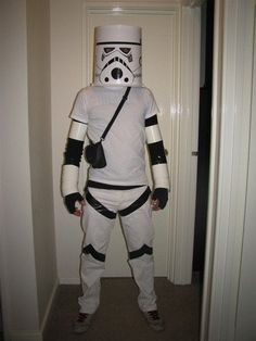 a man dressed up as storm trooper standing in a hallway with his hands on his hips