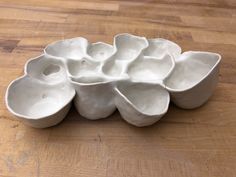 a bunch of white bowls sitting on top of a wooden table