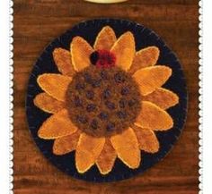 an embroidered sunflower on a black plate