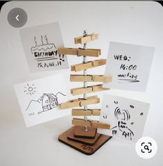 a wooden christmas tree made out of clothes pegs on top of coasters and cards