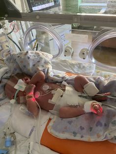 a baby laying on top of a hospital bed next to an oxygen tube and monitor