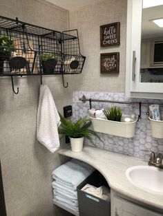 a bathroom with two sinks and hanging baskets on the wall