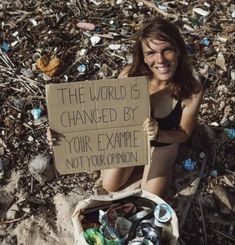 a woman holding a sign that says the world is changed by your example not your opinion