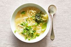 a bowl of soup with noodles, broccoli and parsley on the side