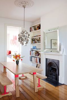 a dining room table with benches and a fireplace