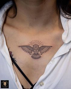 a woman's chest with a bird tattoo on it