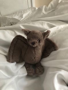 a stuffed animal sitting on top of a white bed