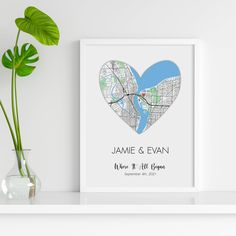 a heart shaped map is displayed on a shelf next to a vase with a plant