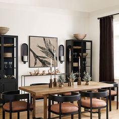 the dining room table is surrounded by black cabinets and chairs with orange upholstered cushions