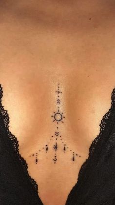 the back of a woman's chest with an arrow and stars tattoo on it