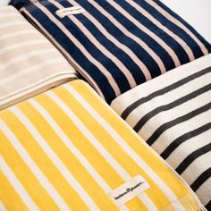 four different colored striped pillows sitting next to each other