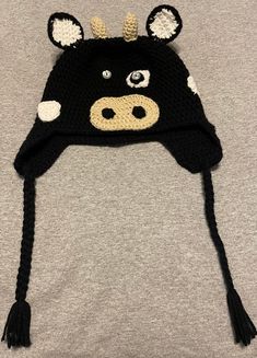 a black and white cow hat on top of a gray t - shirt with ears