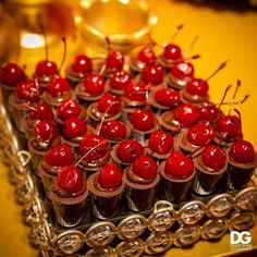 there are many small cups with cherries in them on the tray, ready to be eaten