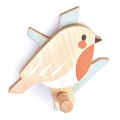 a wooden toy bird sitting on top of a white surface