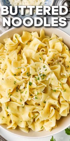 a white bowl filled with pasta and topped with parmesan cheese on the side