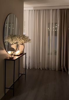 a living room with a mirror and flowers on the table