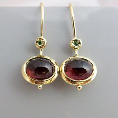 "Beautiful solid gold hanging earrings with oval red Garnet caboshon stone and a small green Tsavorite stone, my favorite color combination. The wine red stones are set in my special designed 14k gold bezel that I hand make by carving wax. This bezel is thicker and heavier than standard bezel, so you can see the gold around the Tourmaline red stone. I designed these hanging earrings so they make you shine in a variety of settings, wherever you go and whatever you wear. The glittering little gree Gold Hanging Earrings, Solid Gold Earrings, Garnet Earrings, Hanging Earrings, Red Stone, Gold Earrings Dangle, Gold Drop Earrings, Gems Jewelry, Stone Earrings