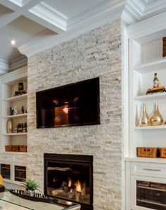 a living room filled with furniture and a flat screen tv mounted on the wall above a fire place