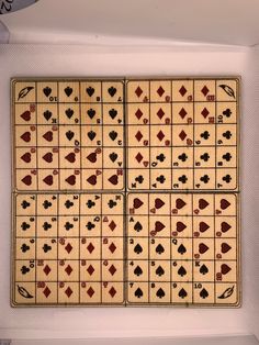 four playing cards are displayed in a white box with red and black designs on them