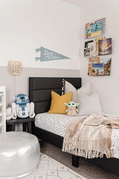 a bed room with a neatly made bed and star wars decorations