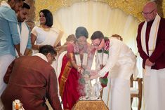 a group of people that are standing around a cake