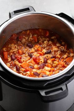 a pot filled with pasta and beans on top of a stove