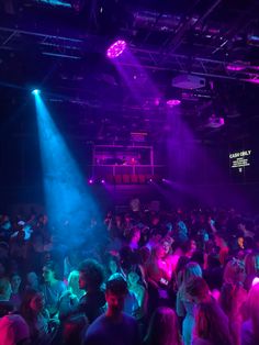 a large group of people in a room with purple and blue lights