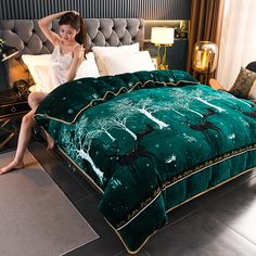 a woman sitting on top of a bed next to a green comforter and pillows