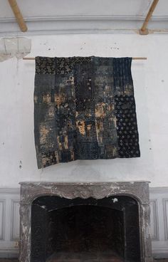 an old rug hanging on the wall next to a fireplace