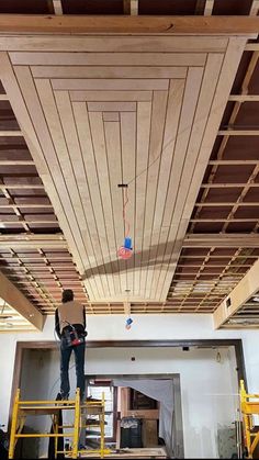 a man is standing on a scaffold in the middle of an unfinished room