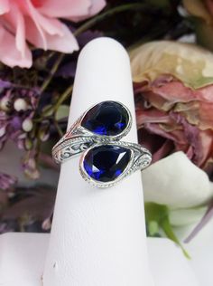 Simulated Sapphire Ring Description Swirl Snake Design#221 MADE TO ORDER This gorgeous ring is a Vintage/Retro inspiration in solid sterling silver. The lovely ring is set with 2 man-made/simulated sapphire gemstones, approximately 2.5ct each, 5ctw. The teardrop cut sapphire blue gem are an eye-catching unique design. The inside of the band is marked 925 for sterling. Notice the beautiful unique design of the silver filigree setting. This ring is fun and very comfortable to wear. This ring reall Sapphire Teardrop Sterling Silver Ring, Blue Sterling Silver Teardrop Ring, Sterling Silver Teardrop Blue Ring, Blue Teardrop Sterling Silver Ring, Ring Teardrop, Retro Inspiration, Blue Sapphire Ring, Snake Design, Blue Gems